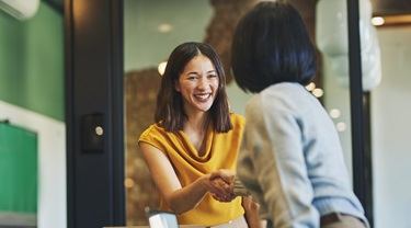 Une femme d’affaires asiatique serre la main d’un client.