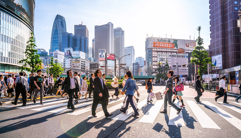 Des gens traversant la rue dans le quartier commercial de Shinjuku à Tokyo, au Japon.